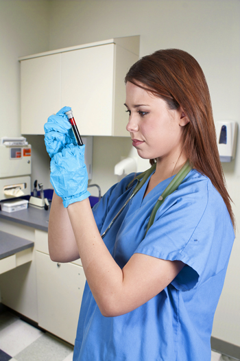 Lab tech looking at blood in tube